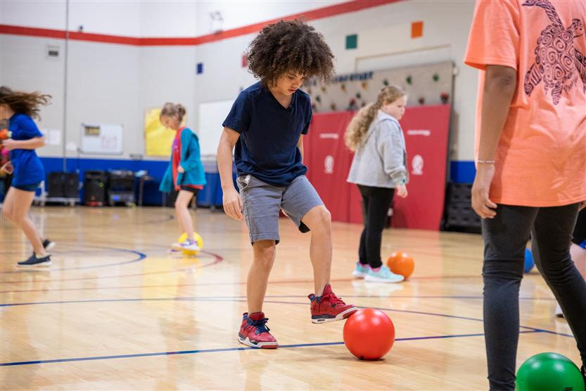 A student practices kicking a soccer ball
